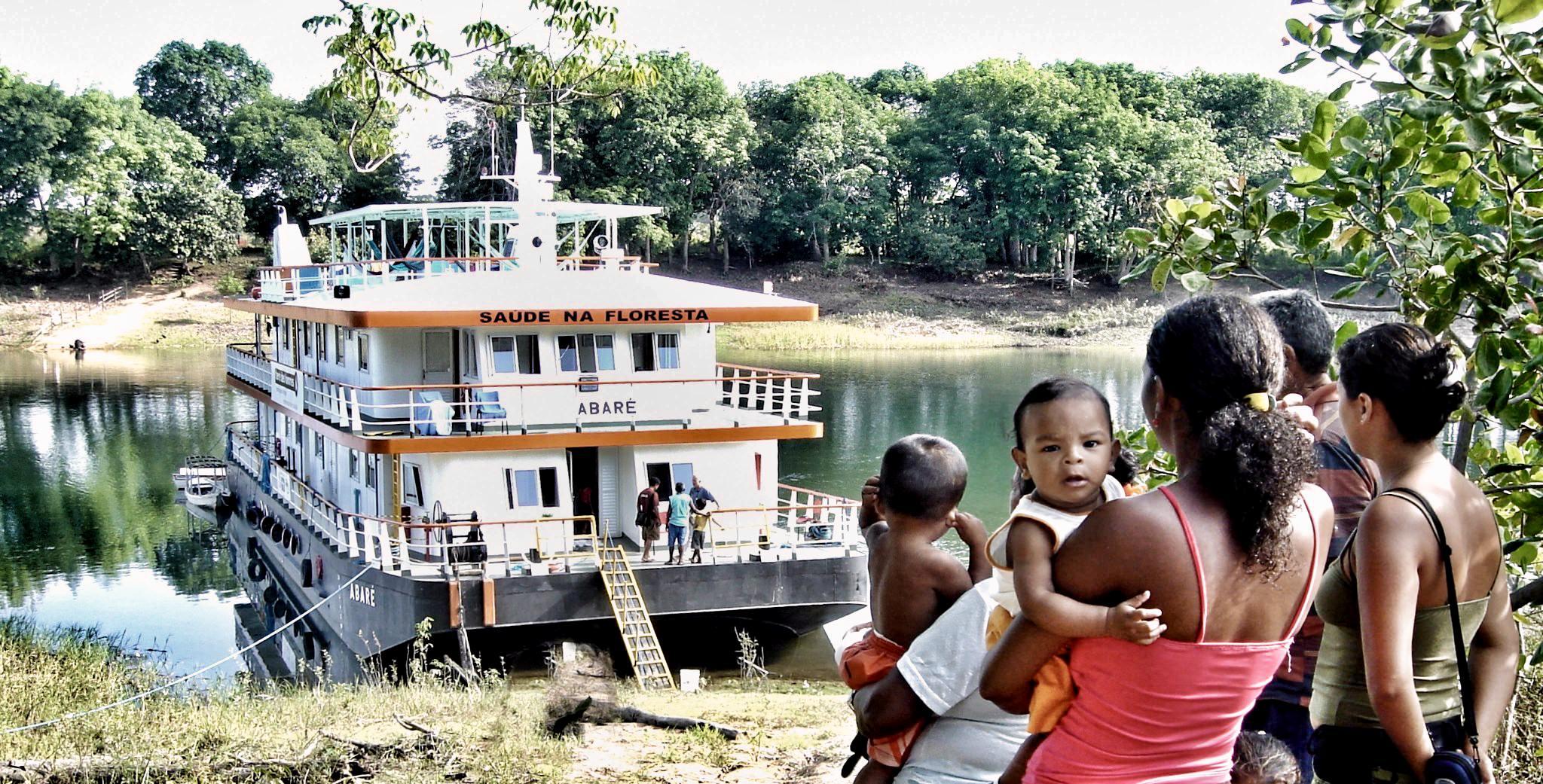 Pessoas sentadas na grama em frente a água

Descrição gerada automaticamente com confiança baixa